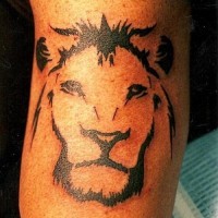 El tatuaje minimalista sencillo de la cabeza de un león en negro hecho en la mano