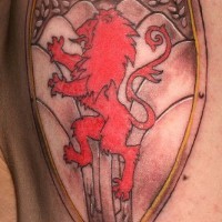 El tatuaje heraldico de un leon rojo encima de un escudo de acero
