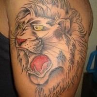 El tatuaje de la cabeza de un leon rugiendo con ojos de color en el brazo o hombro