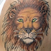 El tatuaje de la cabeza de un leon con ojos verdes hecho a colores