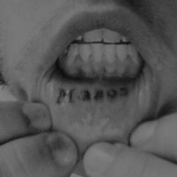 Lip tattoo, manos, black name, near teeth