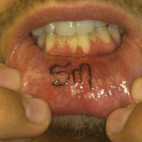 Lip tattoo, sm, two letters, black styled inscription