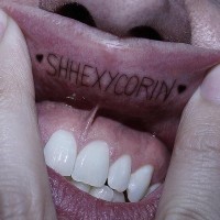 Tatuaje en el labio, inscripción larga, shhexycorin, dos signos, corazón