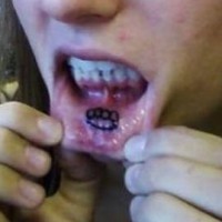Lip tattoo, black sign like teeth