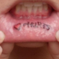 Lip tattoo, red heart and inscription hurts