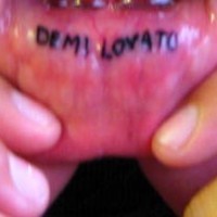 Lip tattoo, demi lovato , two black words