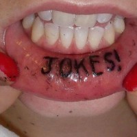 Le tatouage sur la lèvre d'une inscription blagues en noir à lettres gros