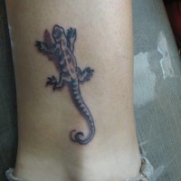 El tatuaje pequeño de una lagartija en 3d en la pierna