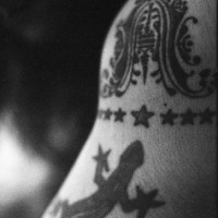 Black lizard with stars and crest tattoo