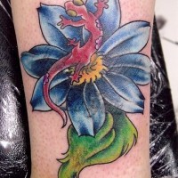 El tatuaje de una lagartija en una flor de colores hecho en la pierna