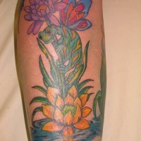 El tatuaje de una lagartija en unos flores en el agua hecho en color