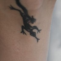 El tatuaje pequeño de una lagartija de color negro