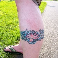 el tatuaje de una flor de loto de color rosa en aguas hecho en la pierna