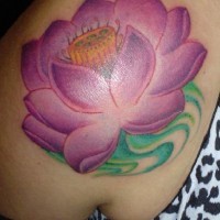 el tatuaje de una flor de loto en color morado hecho en el hombro