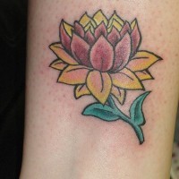 el tatuaje de una flor de loto amarilla con tallo verde en la pierna