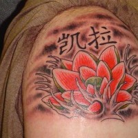 el tatuaje de una flor de loto roja con unos jeroglificos hecho en el hombro