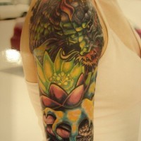 el tatuaje muy bonito de una flor de loto con un dragon asiatico de color verde hecho en el brazo