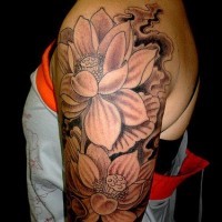 el tatuaje detallado hecho en color negro de dos flores de loto