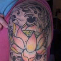 el tatuaje de una flor de loto en aguas negras hecho en el hombro