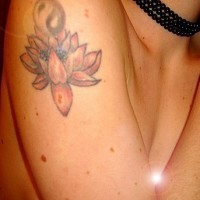 el tatuaje de una flor de loto con el simbolo de yin yang hecho en el hombro