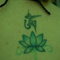 el tatuaje de una flor de loto azul con una mantra hecho en la espalda