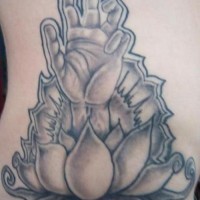 El tatuaje de una flor de loto con una mano humana en color negro