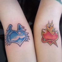 el tatuaje para la pareja de dos corazones  contrarios de color azul y otro rojo hecho en las manos
