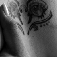 Human eyes in heart symbol tattoo