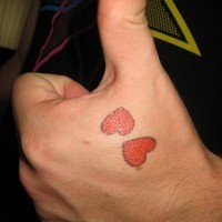 el tatuaje sencillo de dos corazones rojos hecho en la mano