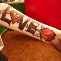 Large love word with red rose tattoo on arm