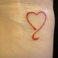 el tatuaje minimalista lineado de un corazon rojo hecho en la muñeca