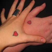 Similar red heart tattoos on lovers