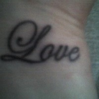 Love lettering tattoo on wrist