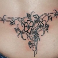 Lower back tattoo, black and white flowers on  braided plant