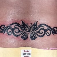 Lower back tattoo, black designed butterfly in pattern
