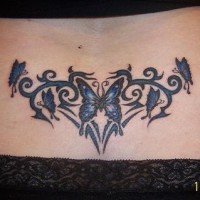 Lower back tattoo, many dark blue butterflies flying in curled lawn