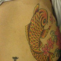 Lower back tattoo, nice, yellow fish swimming in flowers