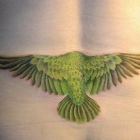Lower back tattoo, green flying bird, turned back