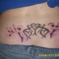 Lower back tattoo, three designed hearts and styled drops