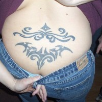 Lower back tattoo, black styled pattern. two parts