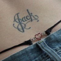 Lower back tattoo, jack, black curled styled name