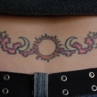 Tatuaje en el bajo de la espalda; precioso sol, tinta negra y roja, luna y estrellas