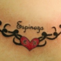 Le tatouage de bas du dos avec un cœur rouge décoré et le mot Espinosa