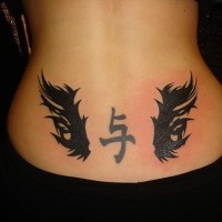 Lower back tattoo,black hieroglyph, styled with wings