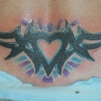 Tatuaggio colorato sulla lombo il disegno in forma di cuore in stile tribale