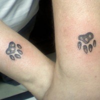 Matching friendship paw print tattoo on wrist