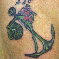 el tatuaje de una ancla verde con una rosa e iniciales