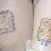 el tatuaje conmemorativo de dos galletas con fechas hecho en color
