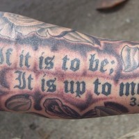 el tatuaje de una cita biblica  3:28 hecho en color negro en el brazo