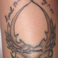 el  tatuaje conmemorativo con de un corazon con alas en forma de traceria con fechas de la vida